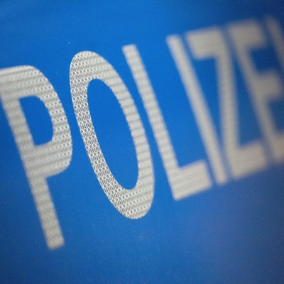 Der Schriftzug „Polizei“ auf einem Streifenwagen.