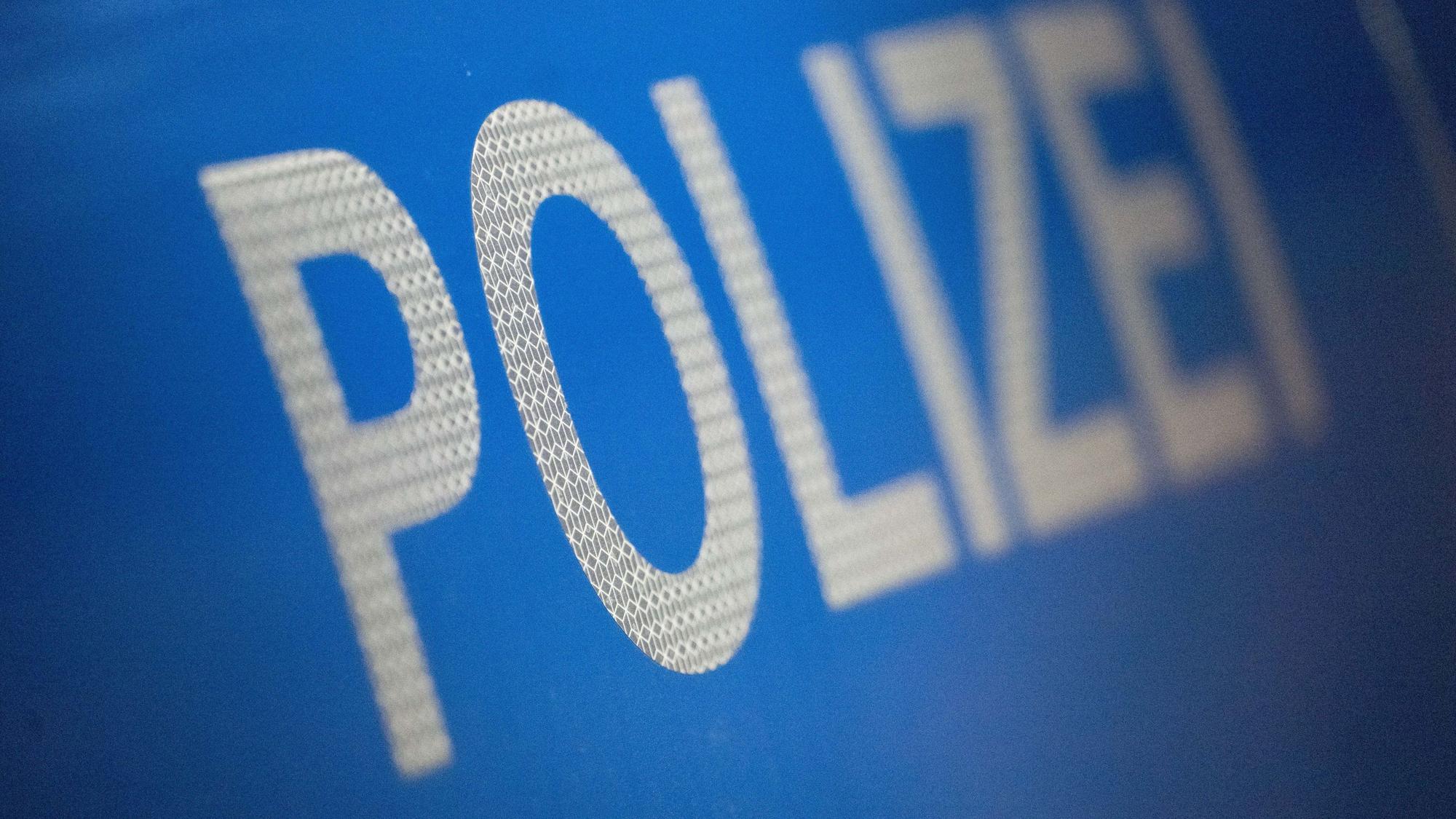Der Schriftzug „Polizei“ auf einem Streifenwagen.