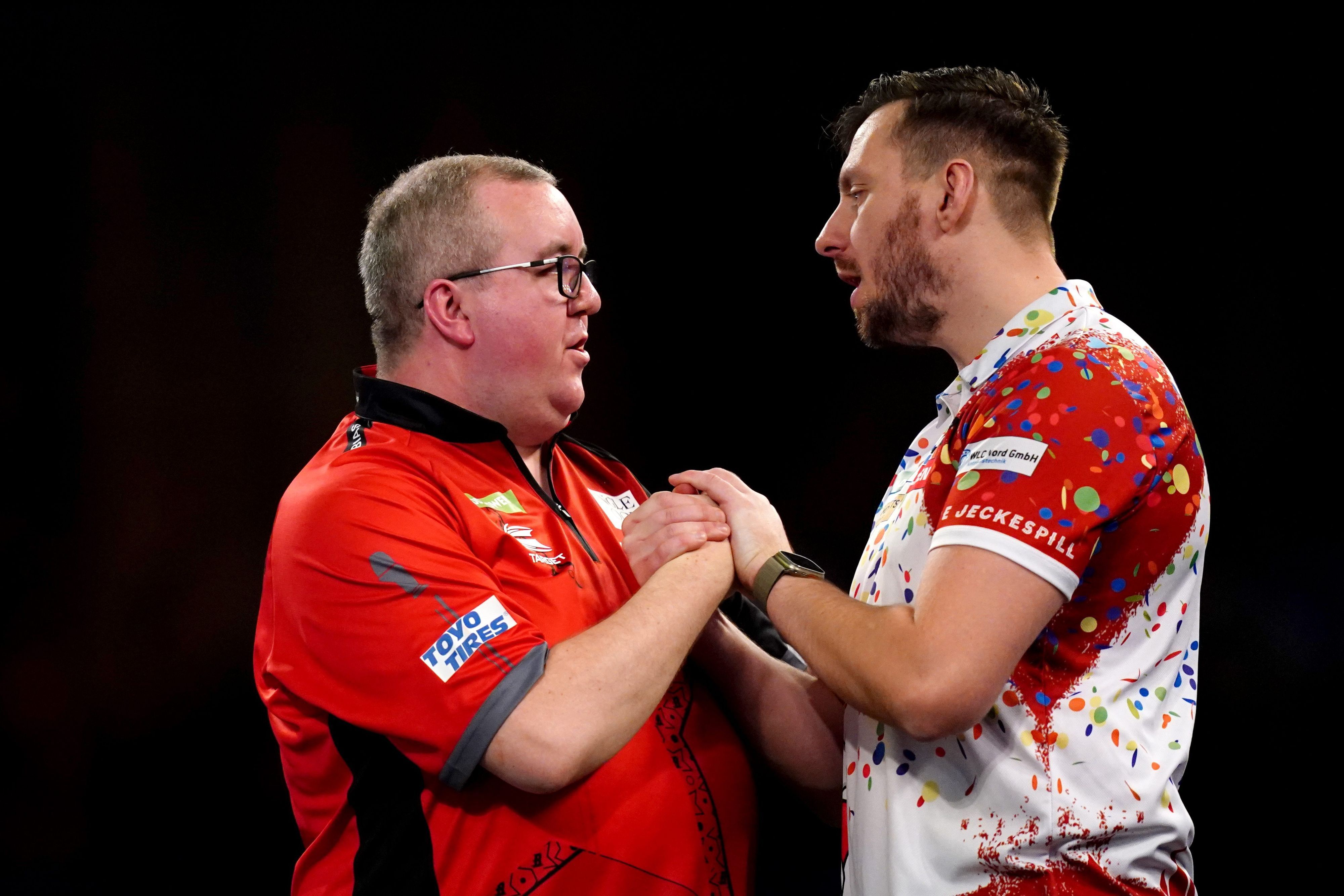 Stephen Bunting (l) wird von Florian Hempel nach seinem Sieg beglückwünscht.