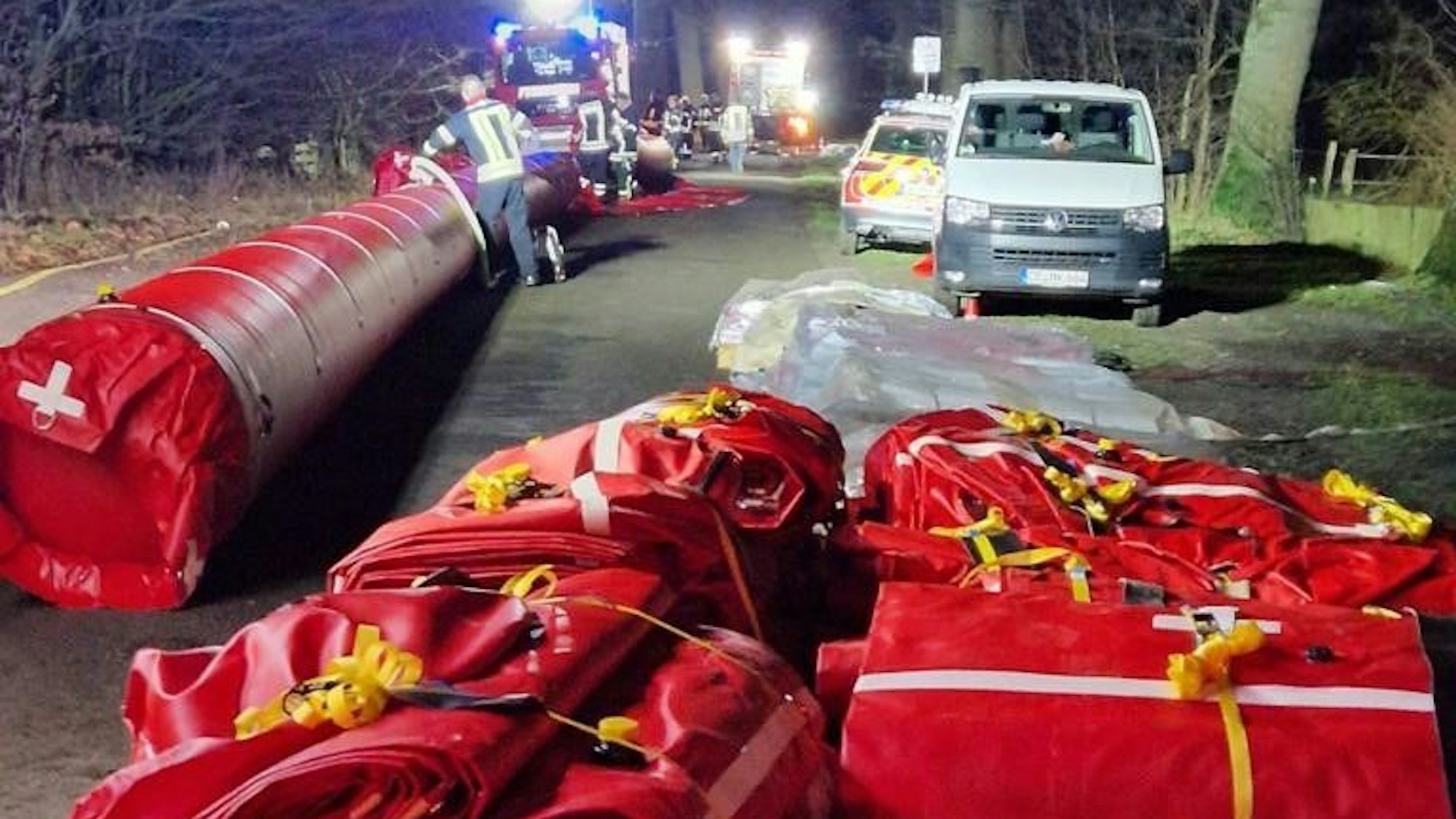 Das Bild zeigt rote Plastikdeiche. Ein Teil davon ist noch verpackt, im linken Bereich des Fotos ist bereits ein Deich aufgepumpt.