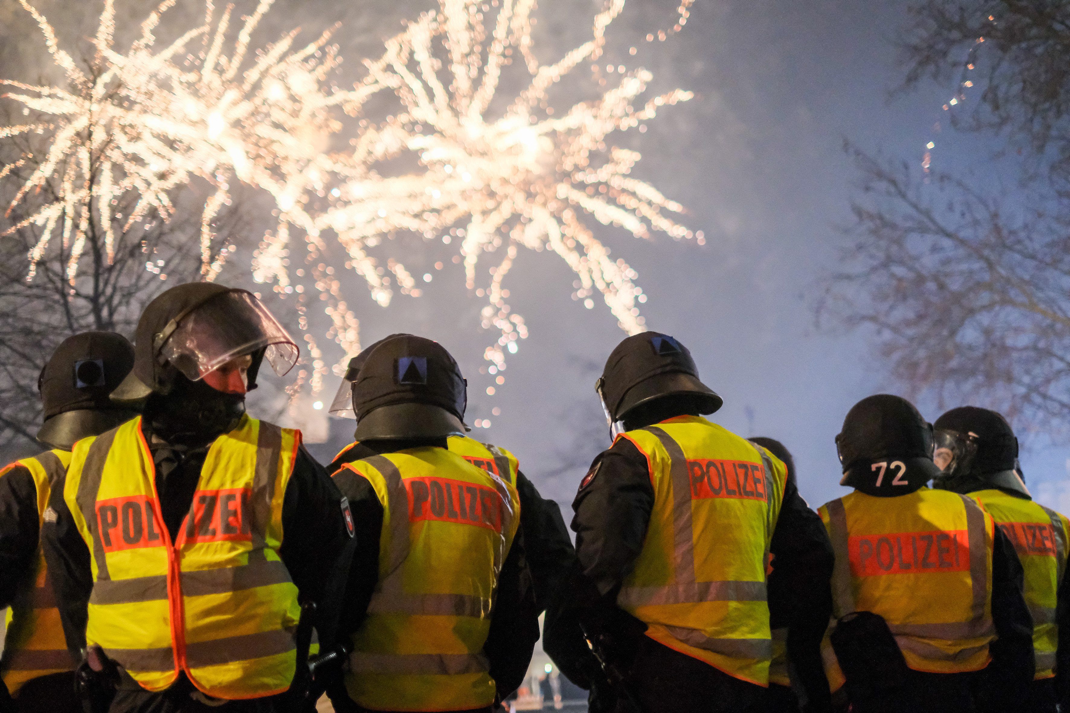 Polizeibeamte stehen in Hannover in der Innenstadt und beobachten ein Feuerwerk.