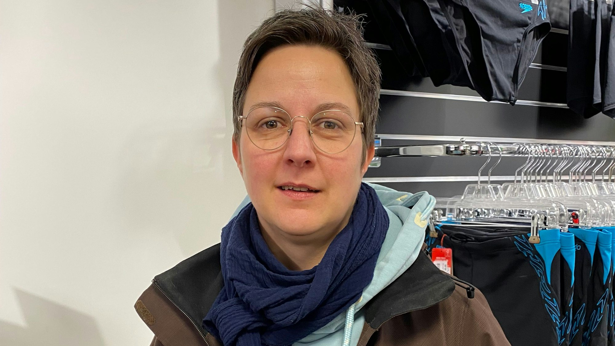 Annette Fleischer steht vor einem Regal mit Sportbekleidung.