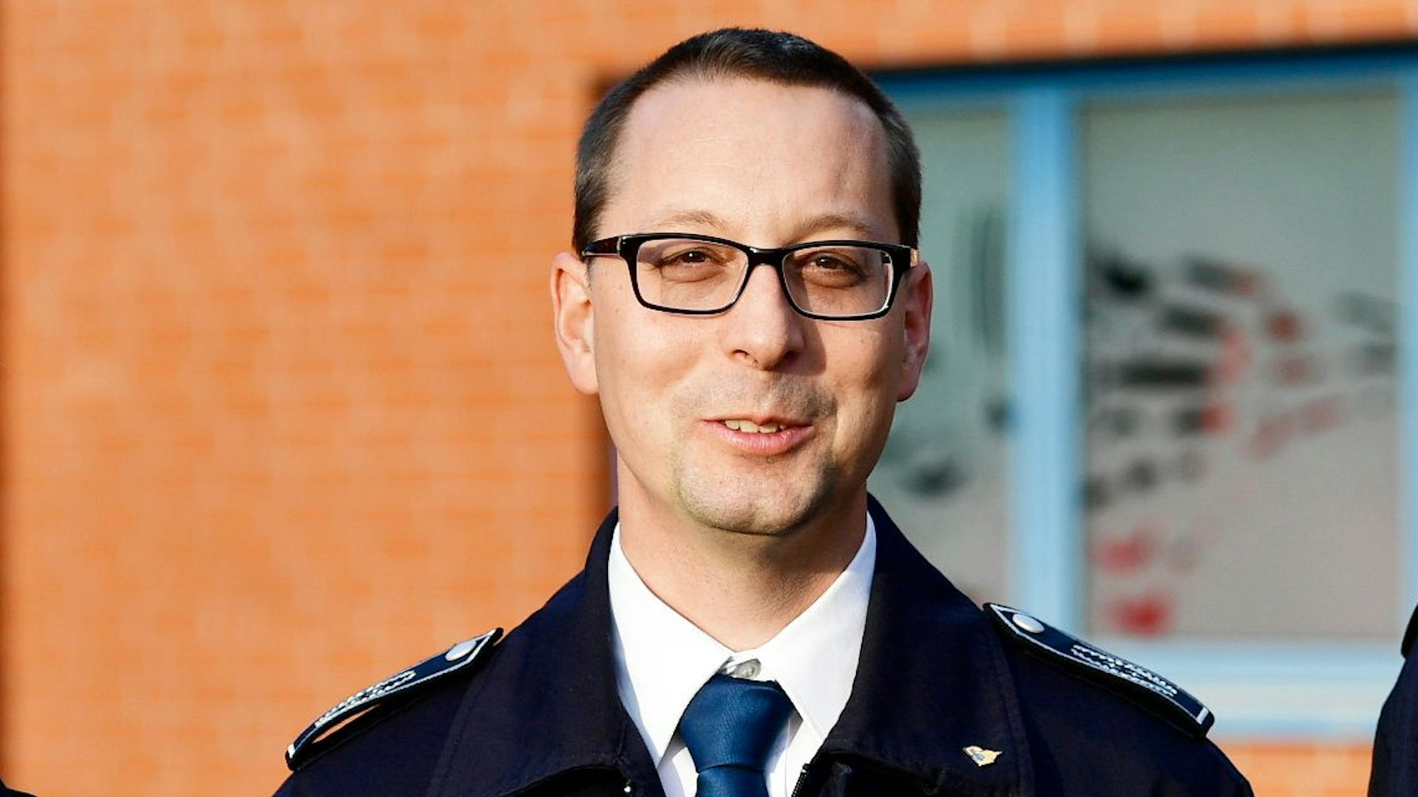 Der Leiter der Feuerwehr Rösrath, Bastian Eltner, steht vor einem Feuerwehrhaus.