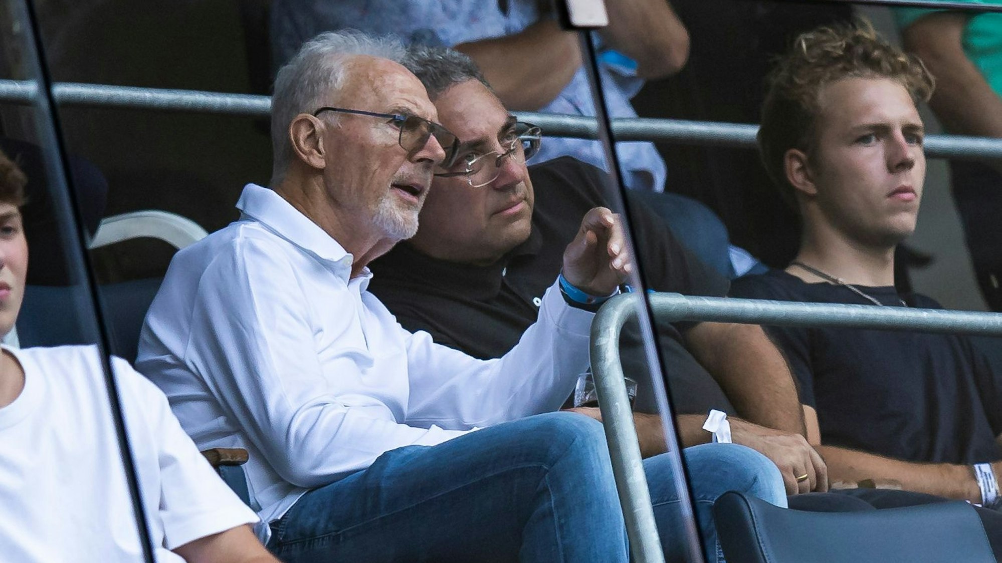 Franz Beckenbauer sitzt auf der Tribüne.