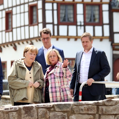 Das Bild zeigt den Landtagsabgeordneten Klaus Voussem, den Bundestagsabgeordneten Detlef Seif, Angela Merkel, NRW-Ministerpräsident Hendrik Wüst, Sabine Preiser-Marian (alle CDU) und Markus Ramers (SPD) auf einer Brücke in Bad Münstereifel.