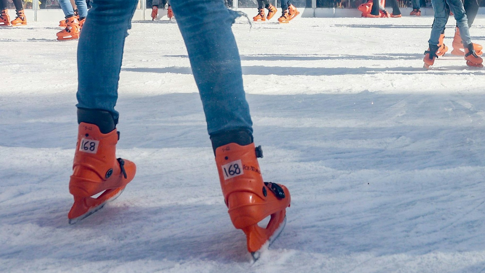 Menschen laufen Schlittschuh.