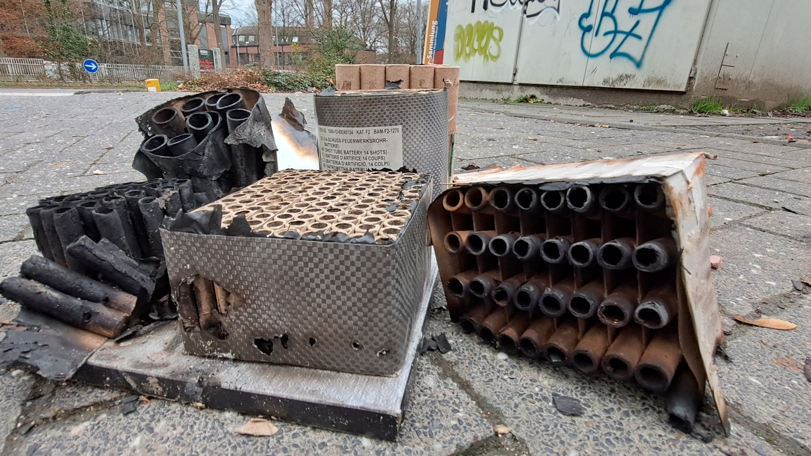 Abgebrannte Reste von Feuerwerkskörpern und Raketen liegen auf der Straße.
