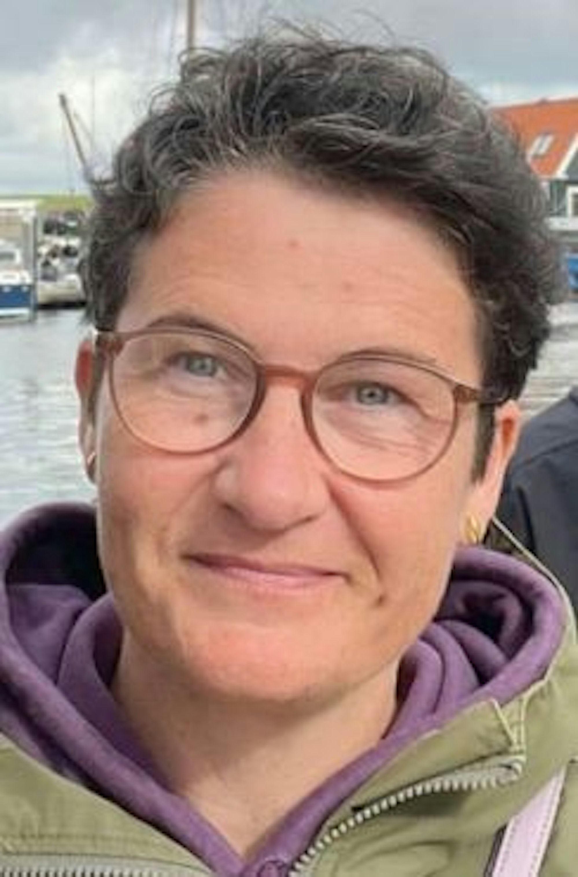 Sabine S. aus Bergisch Gladbach, eine Frau mit brauner Brille, blauen Augen und dunklen Haaren.