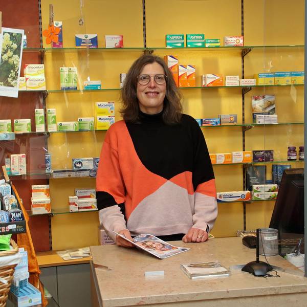 Eine Frau hinter der Verkaufstheke einer Apotheke.