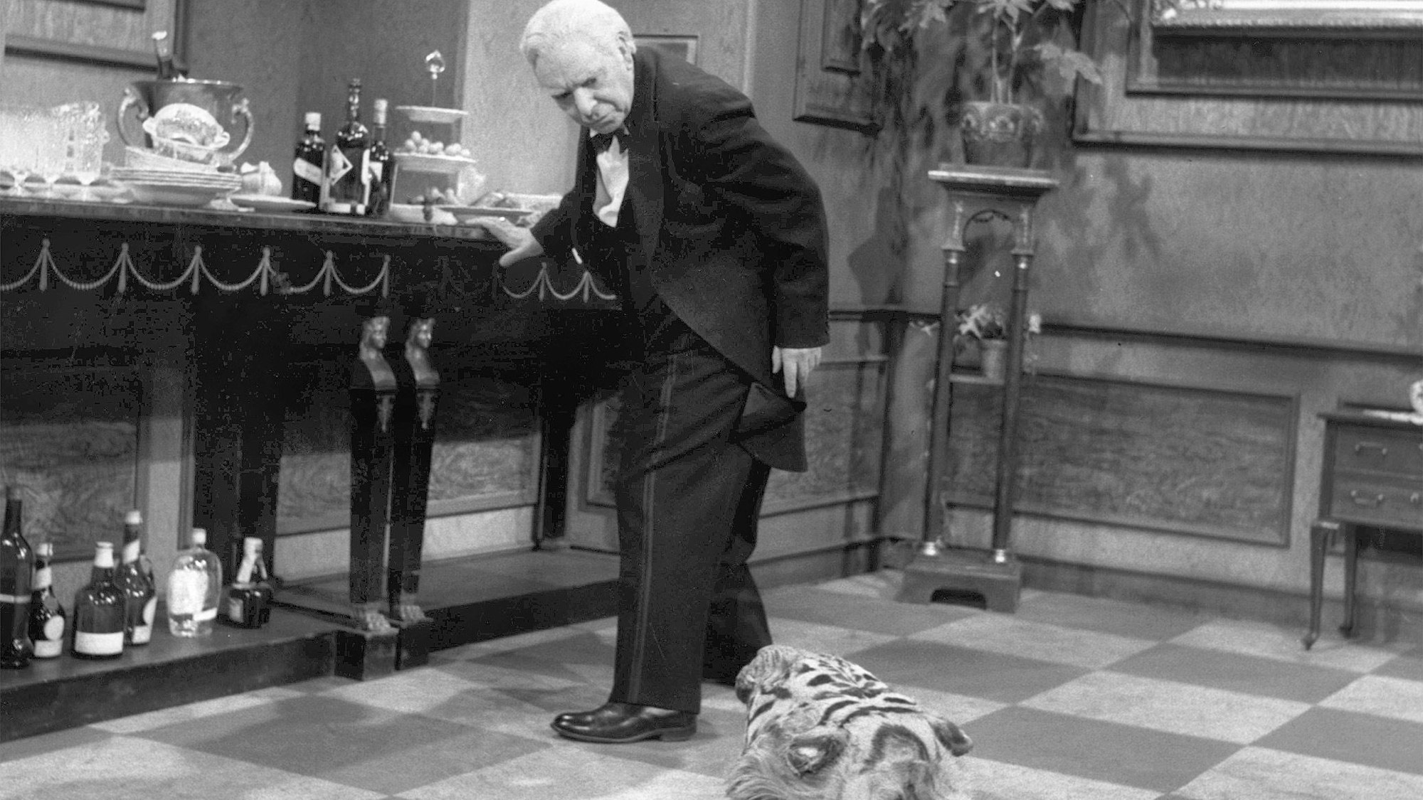 Freddie Frinton als Diener James betrachtet nach einem Stolpern das Tigerfell in einer Szene des Films „Dinner for One“.