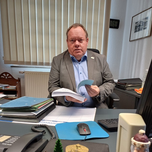 Kurt Reidenbach sitzt am Schreibtisch und hält den Vorentwurf zum Haushalt in der Hand.