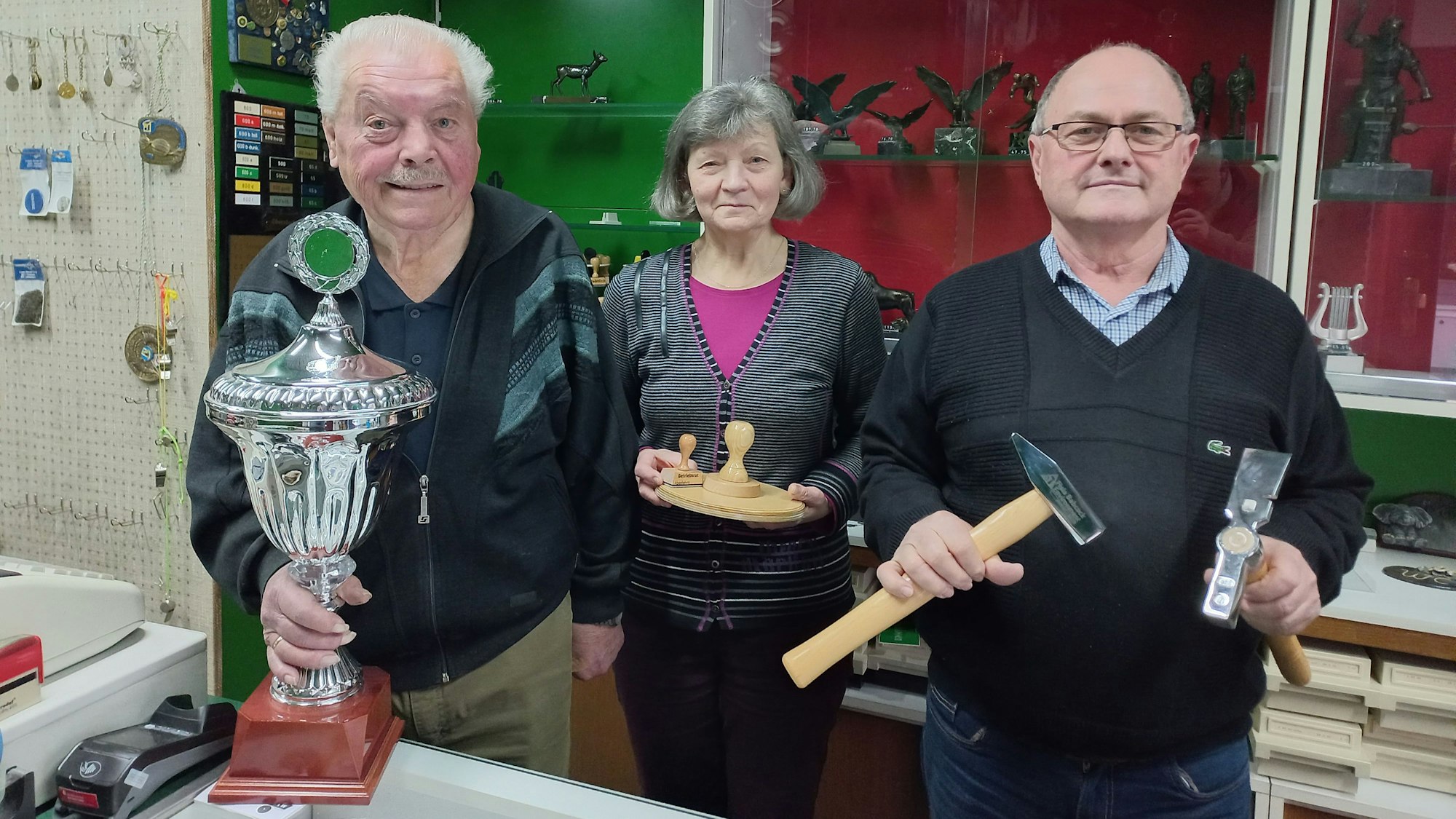 Blick auf drei Menschen in einem Stempel- und Gravuren-Laden.
