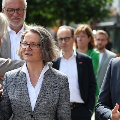 NRW-Heimatministerin Ina Scharrenbach spricht in Euskirchen mit einem Polizisten. Rechts ist Landrat Markus Ramers zu sehen.