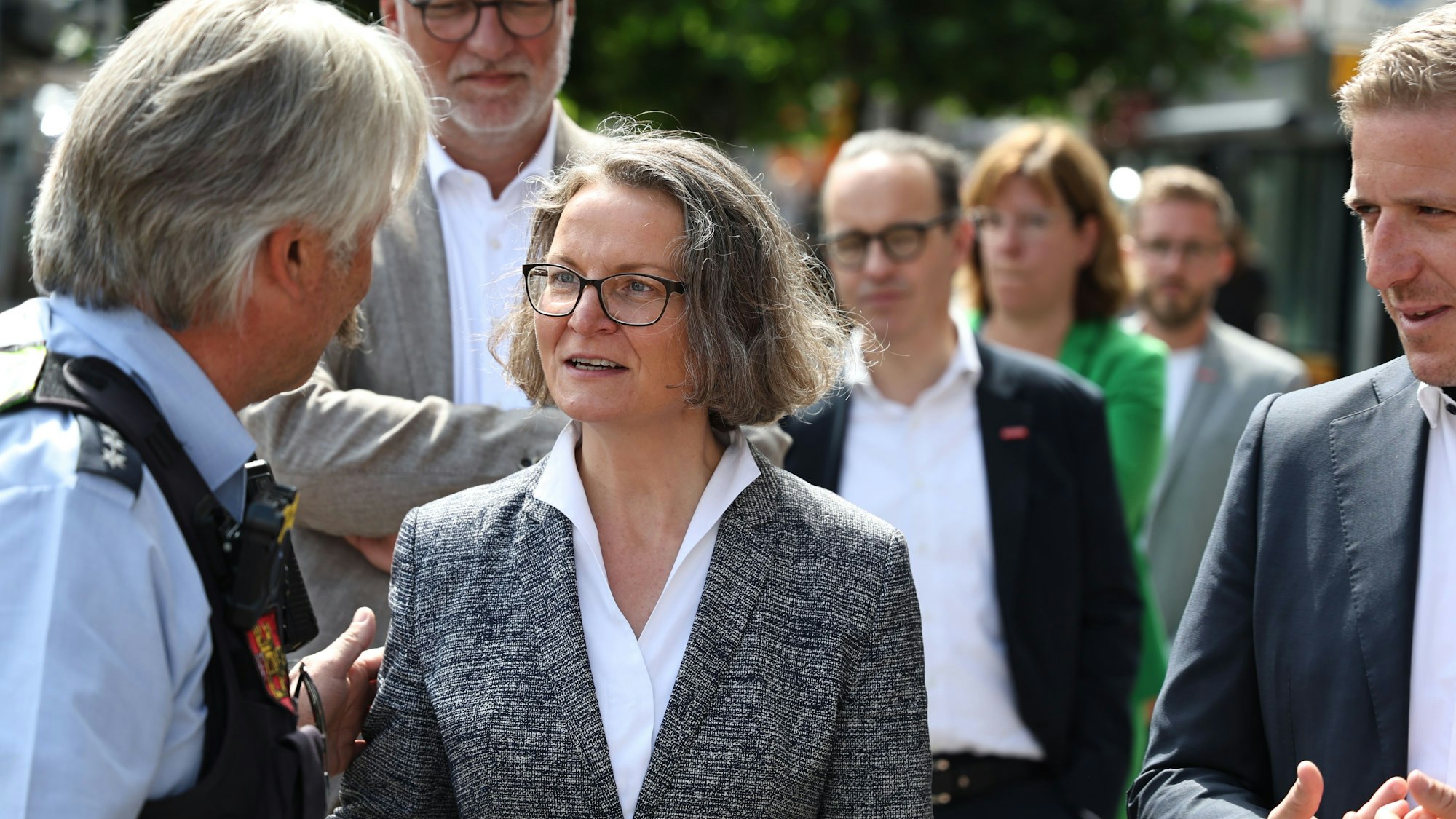 NRW-Heimatministerin Ina Scharrenbach spricht in Euskirchen mit einem Polizisten. Rechts ist Landrat Markus Ramers zu sehen.