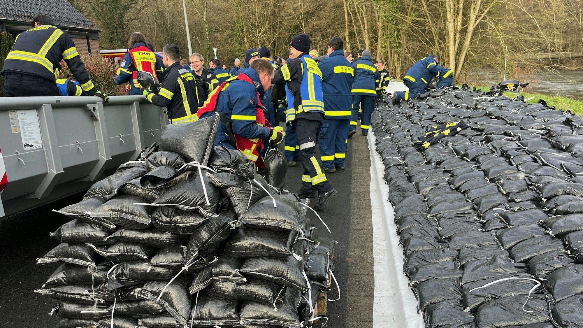 Einsatzkräfte verteilen Sandsäcke.