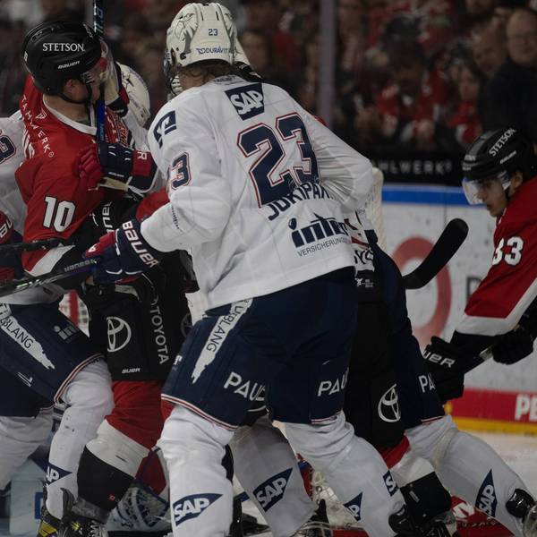 Mehrere Eishockeyspieler kämpfen dicht gedrängt um den Puck.