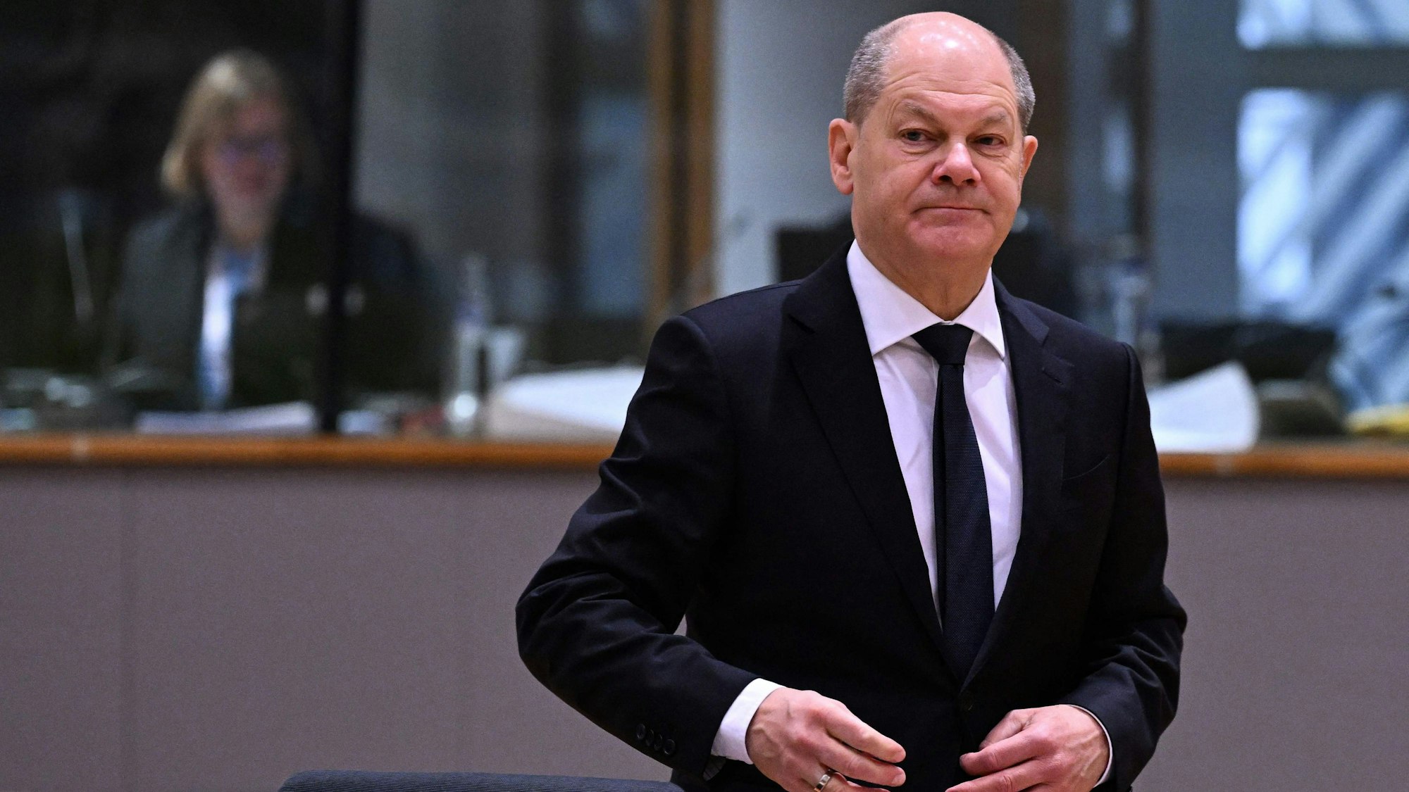 Olaf Scholz trägt einen schwarzen Anzug mit schwarzer Krawatte.