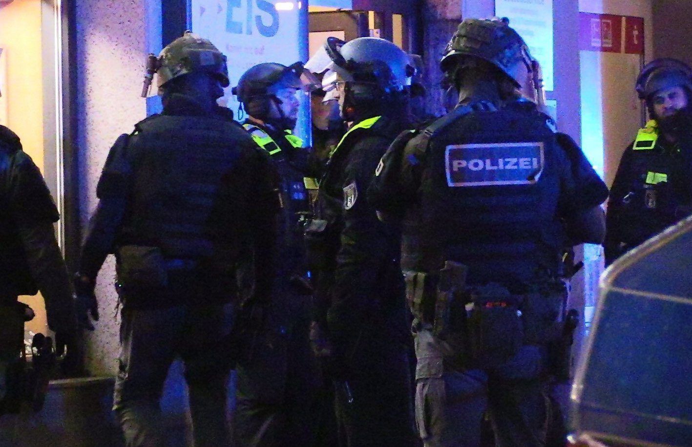 Polizei steht vor einem Hauseingang.