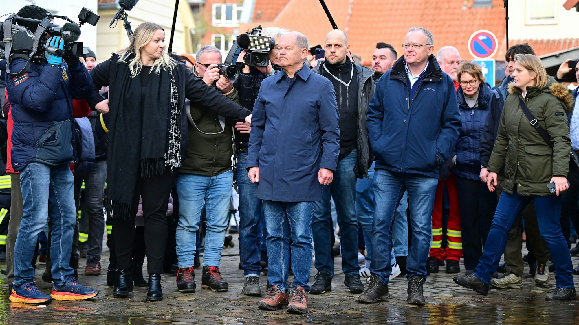 Bundeskanzler Olaf Scholz und Stephan Weil, Ministerpräsident von Niedersachsen, stehen bei ihrem Besuch im Hochwassergebiet an einer überfluteten Straße.
