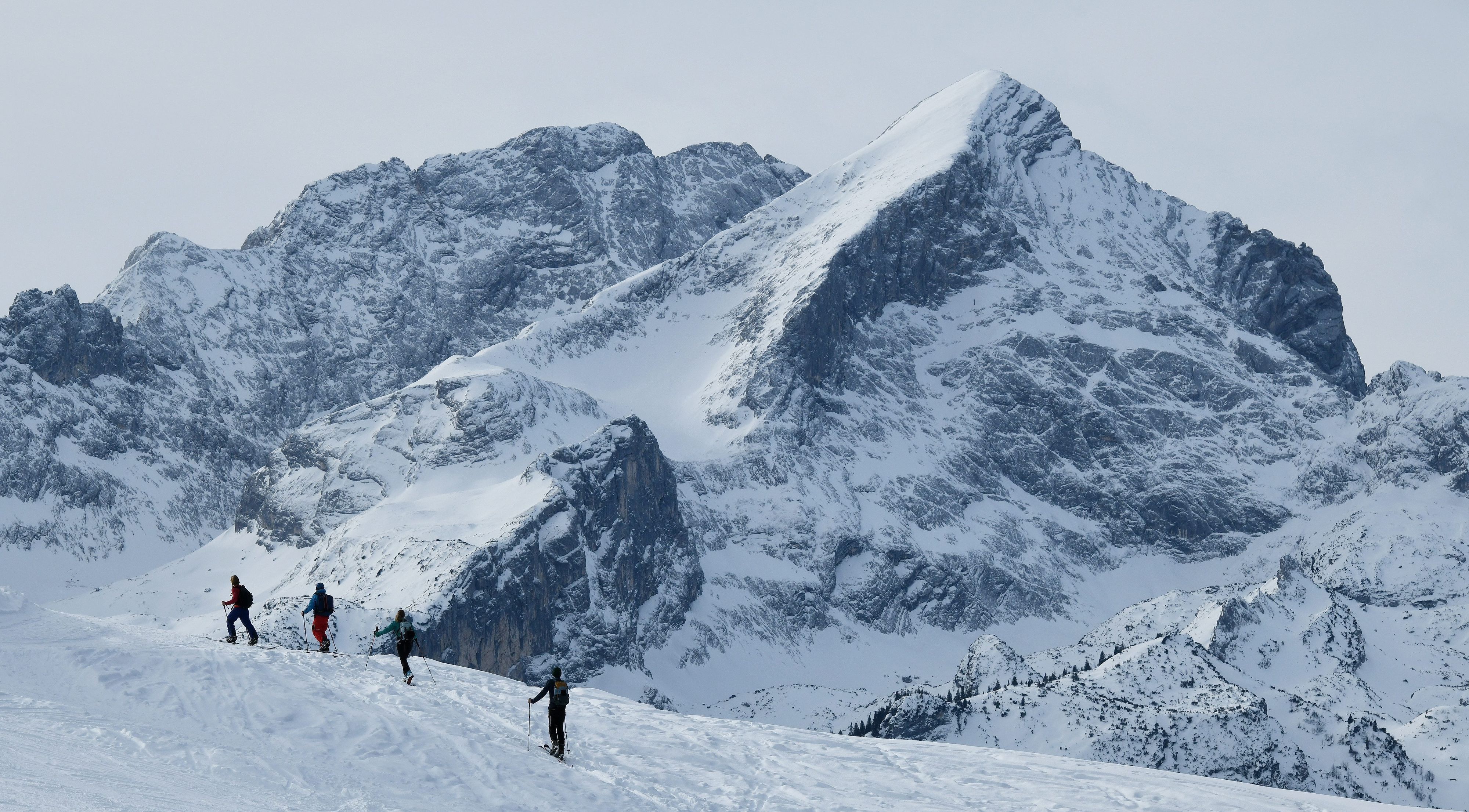 Skitourgänger sind im Wettersteingebirge unterwegs. Im Hintergrund sind schneebedeckte Berge zu sehen.