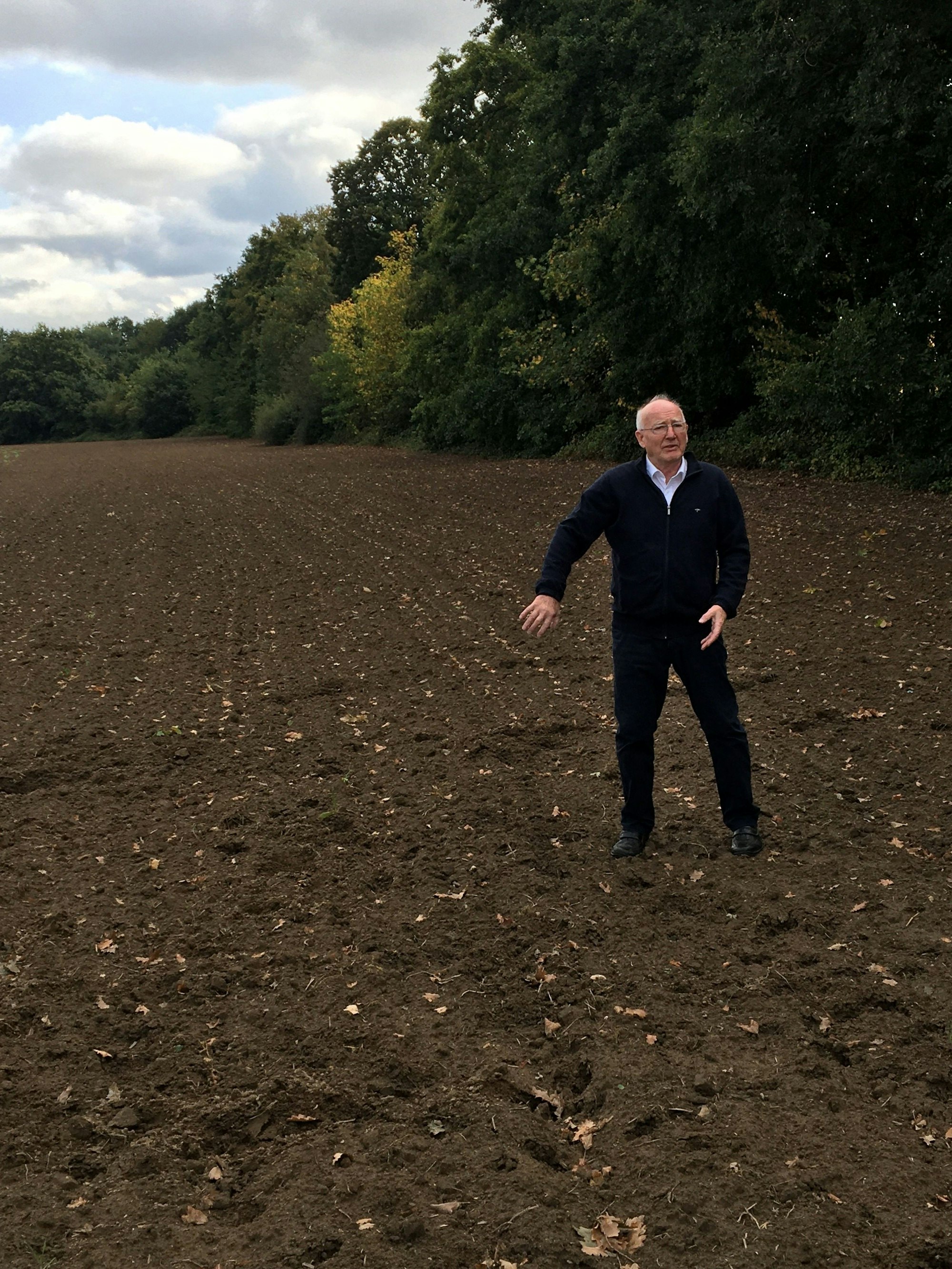 Ein Mann steht auf einem Acker.