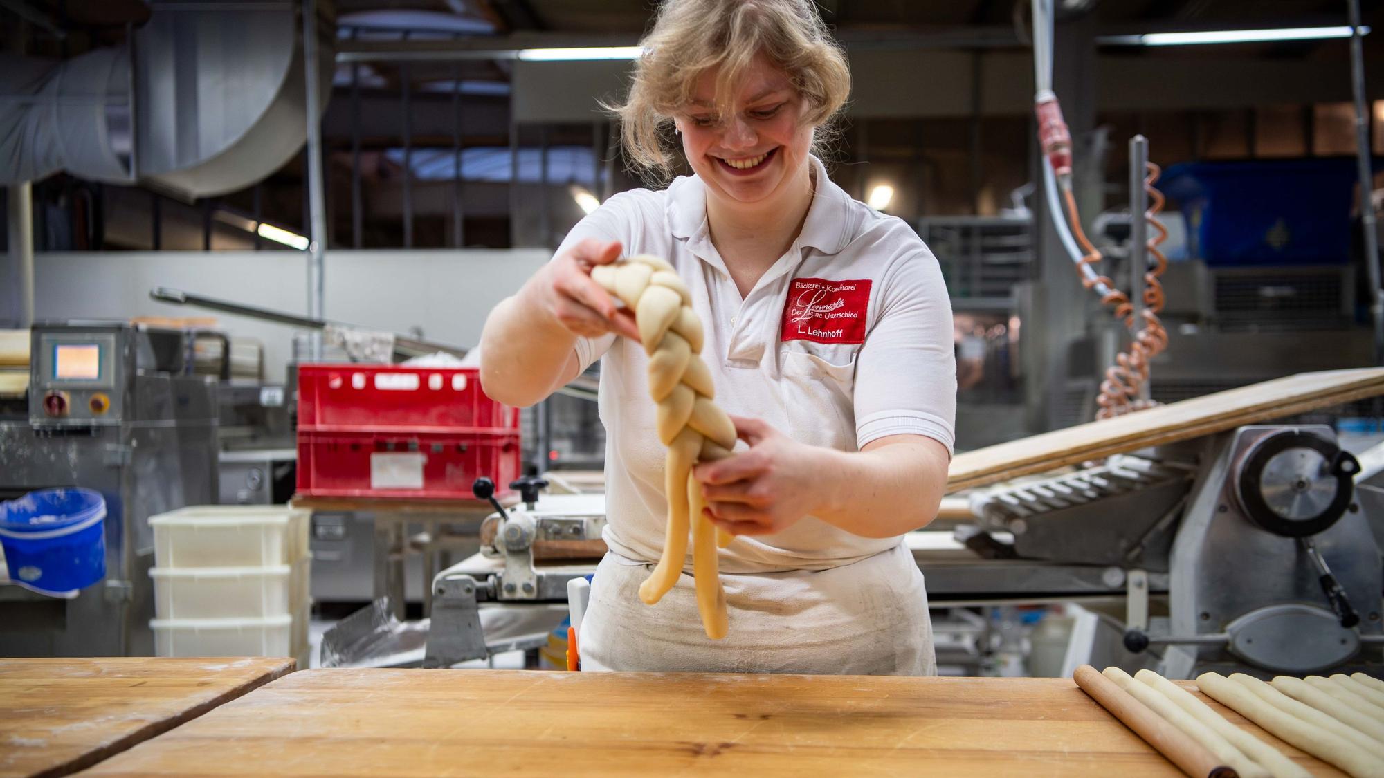 Das Bild zeigt Lea Lehnhoff beim Flechten eines Neujahrskranzes.