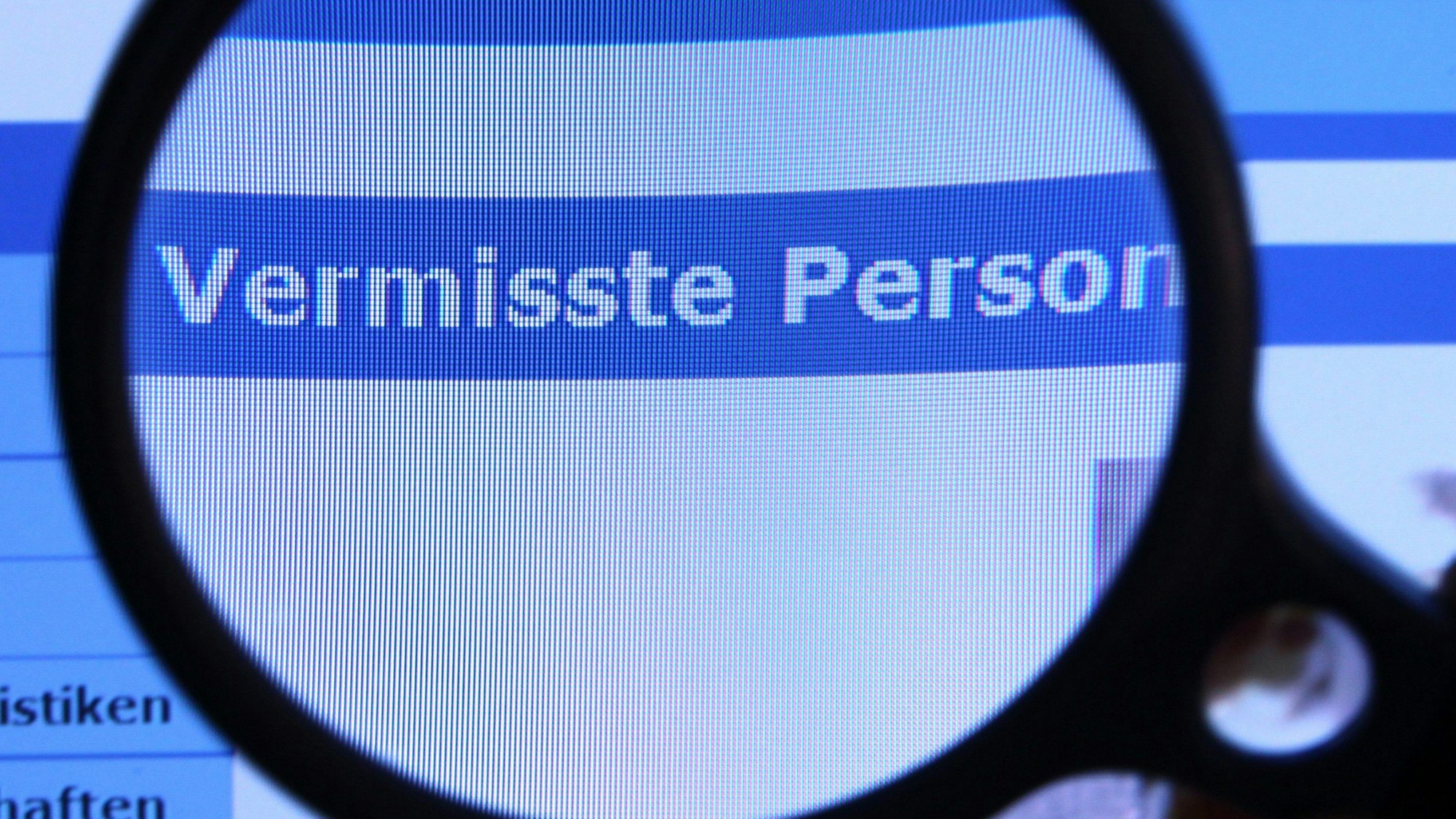 Hinter einer Lupe ist der Schriftzug „Vermisste Person“ auf einem Fahndungsaufruf auf der Internetseite des Bundeskriminalamtes (BKA) zu sehen.