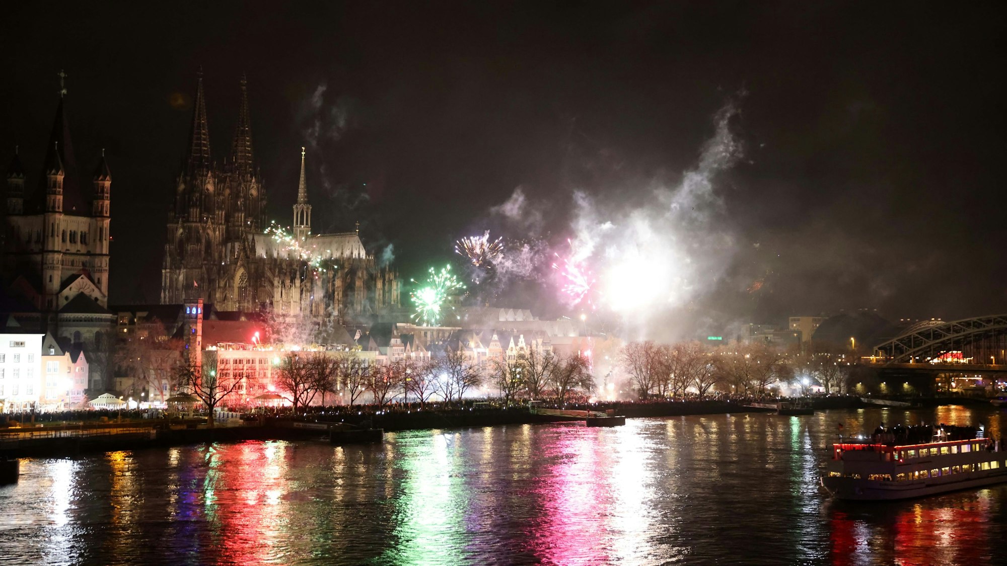 Buntes Feuerwerk erleuchtet den Nachthimmel über dem Rhein.
