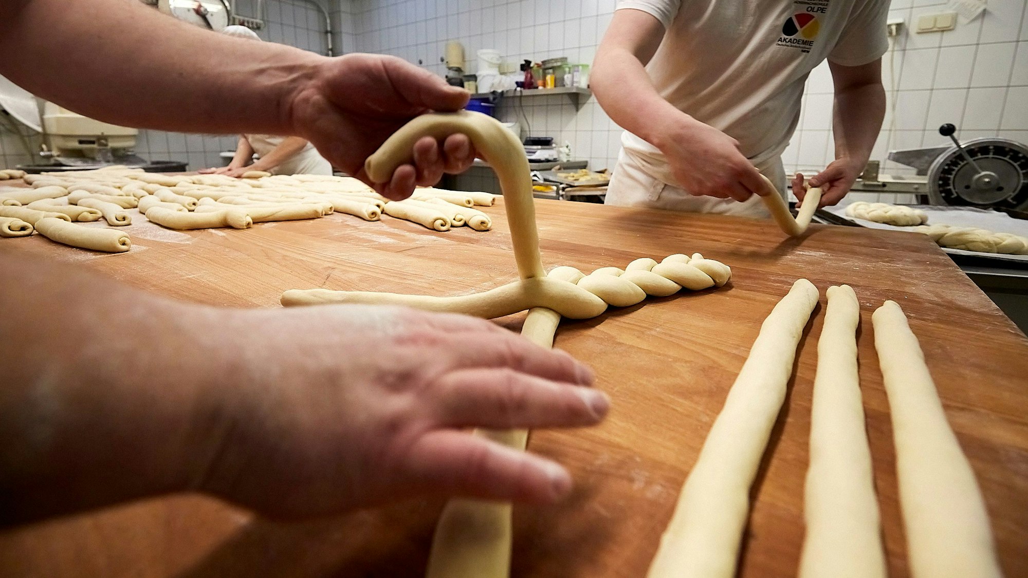 Das Bild zeigt eine Nahaufnahme der Herstellung von Neujahrskränzen. Gerade werden die Stränge geflochten.