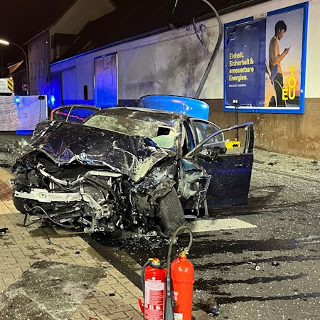 Auf der Provinzialstraße in Niederkassel-Mondorf steht der völlig zerstörte BMW, der ungebremst in eine Bushaltestelle gerast war und einen Jugendlichen tödlich verletzt hatte.