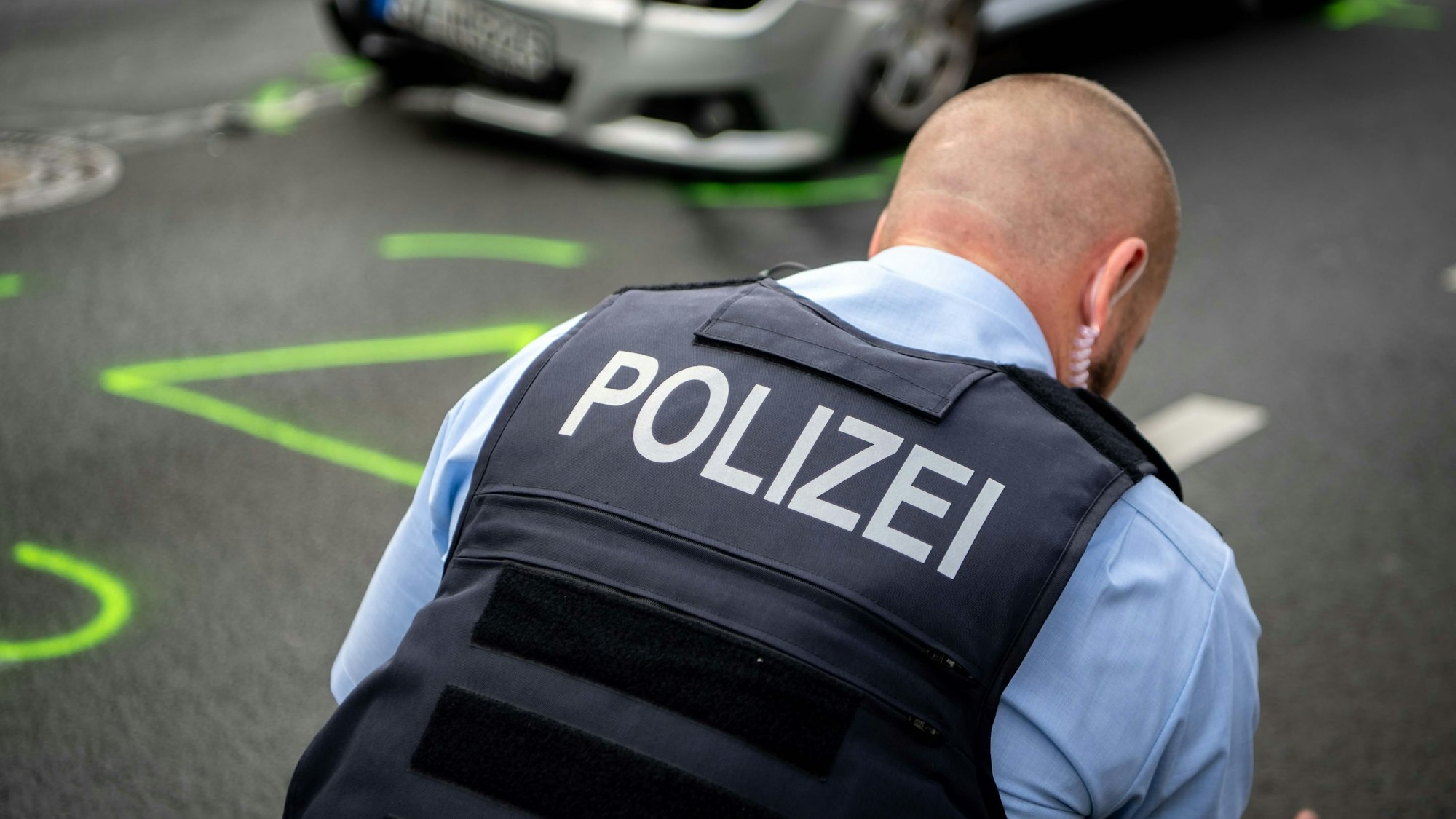 Das Symbolbild zeigt einen Polizisten, der einen Verkehrsunfall aufnimmt.