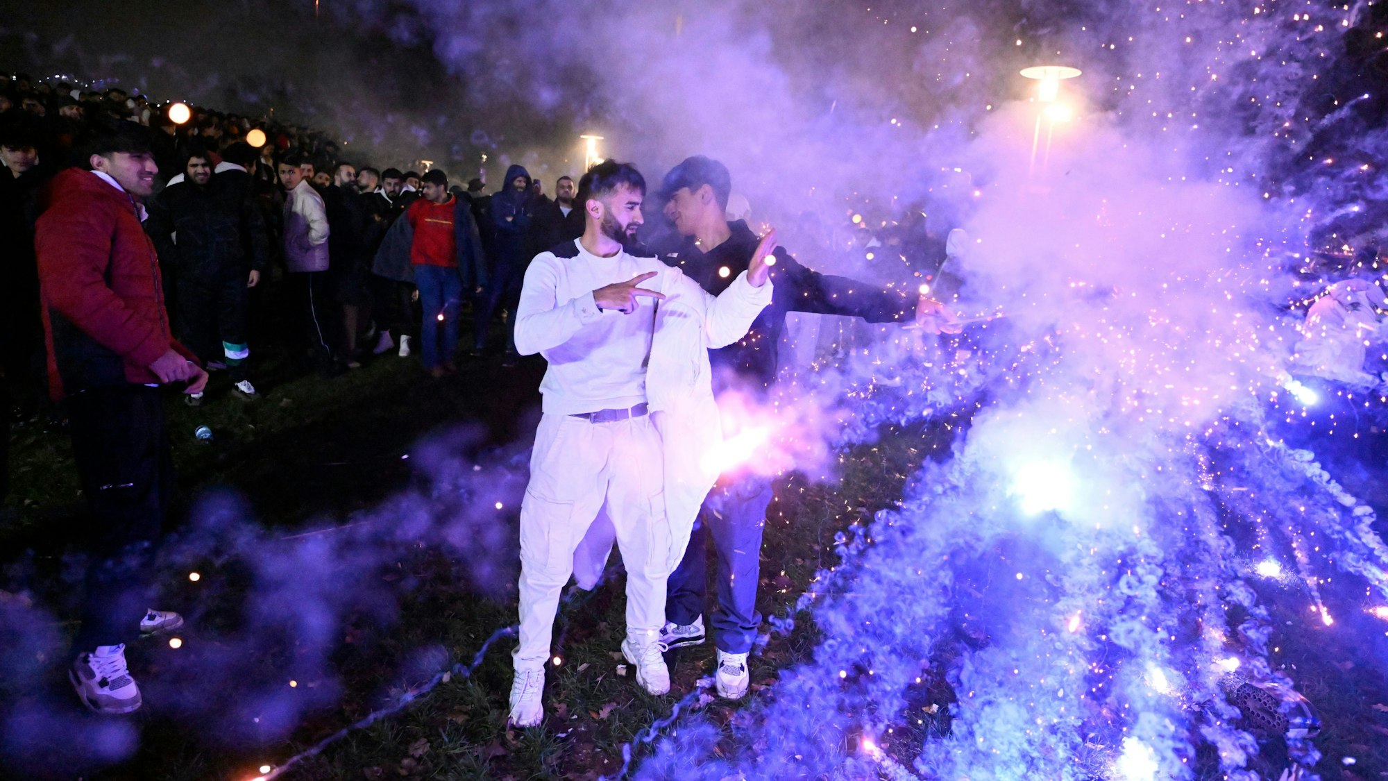 Menschen zünden in der Altstadt Feuerwerkskörper um das neue Jahr 2024 willkommen zu heißen.