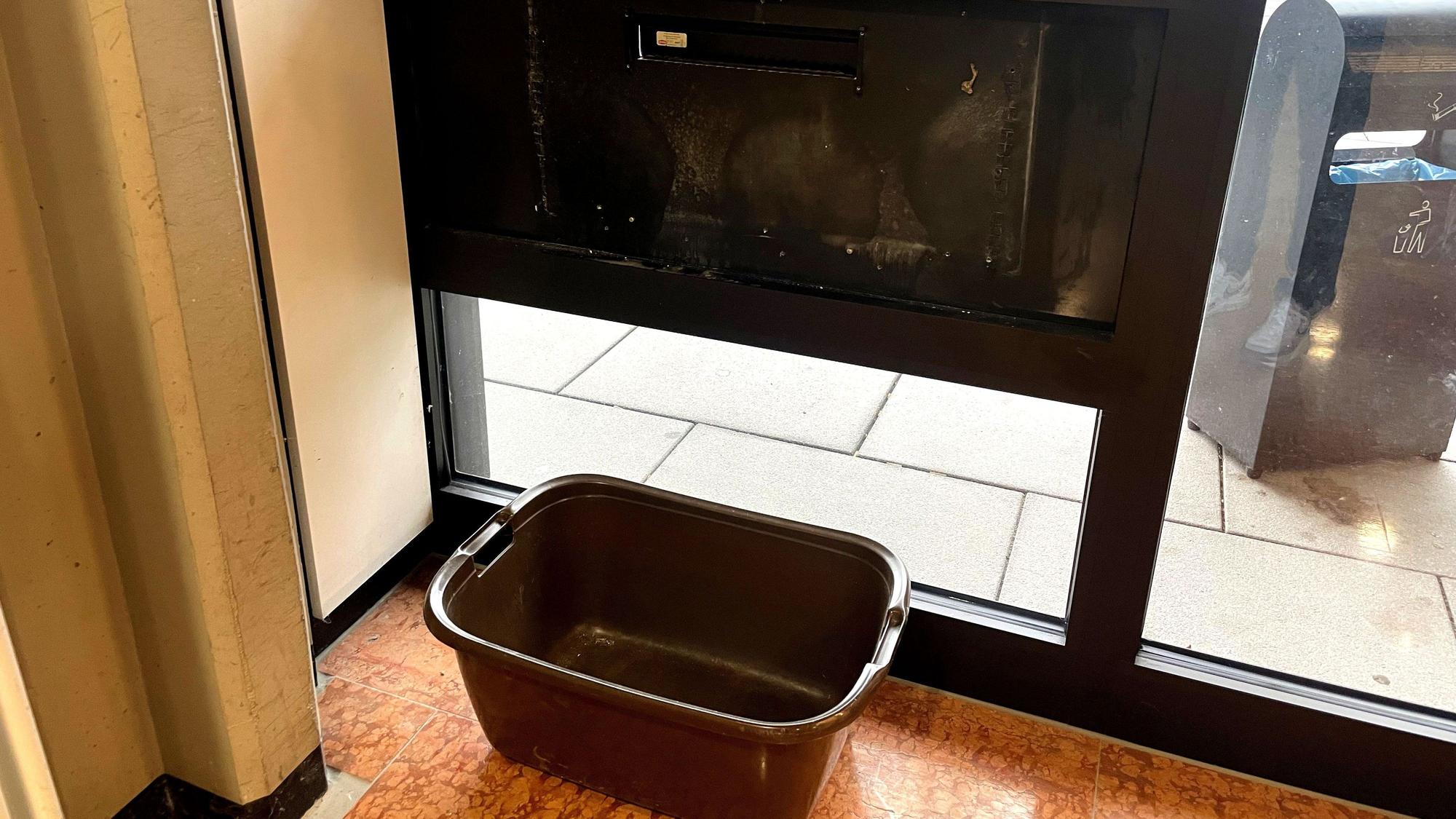 Ein Wäschekorb steht im Inneres des Kreishauses unter dem Briefschlitz.