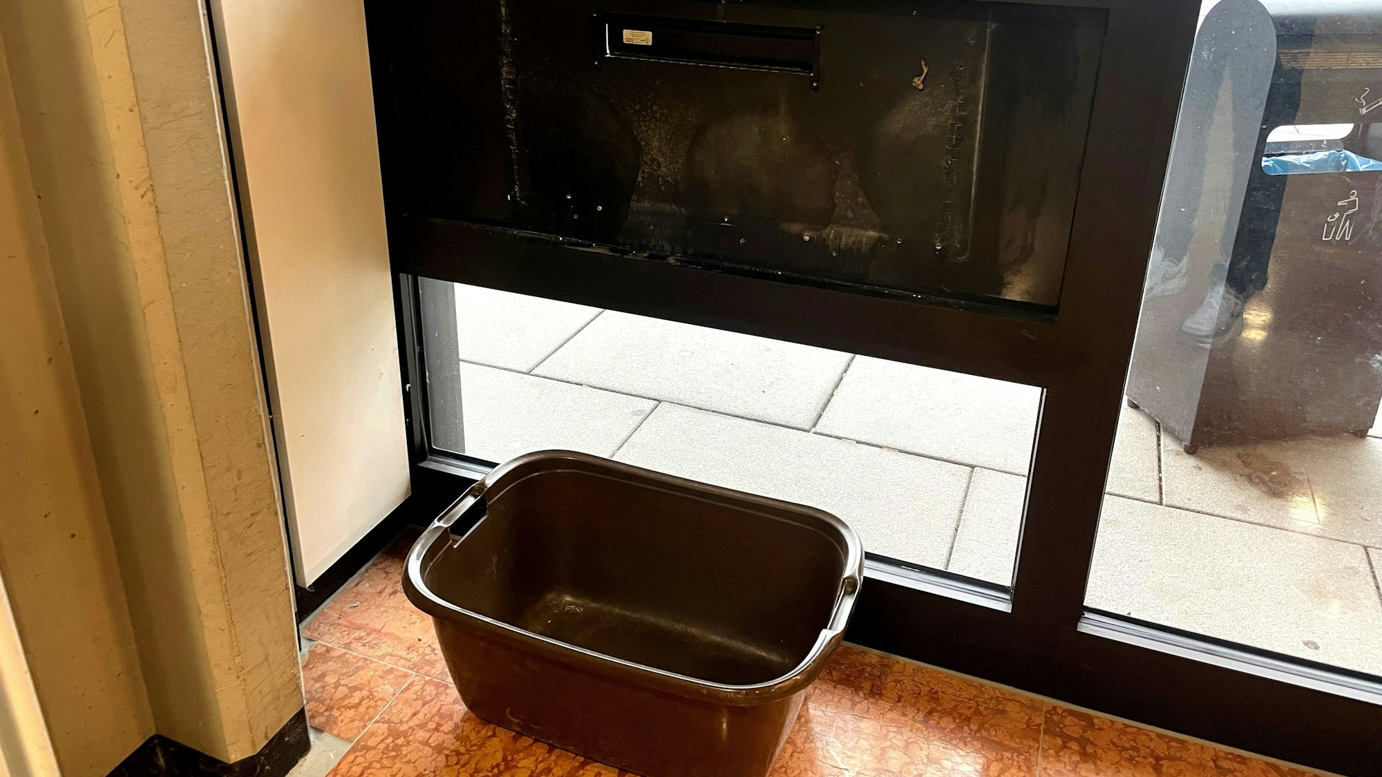 Ein Wäschekorb steht im Inneres des Kreishauses unter dem Briefschlitz.