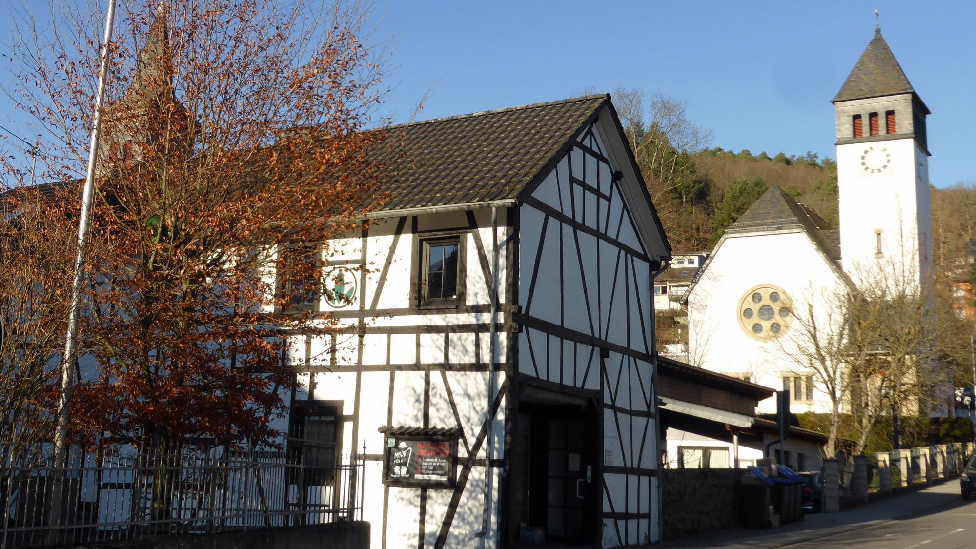Im Vordergrund ist ein Fachwerkhaus, im Hintergrund die Erlöserkirche zu sehen.