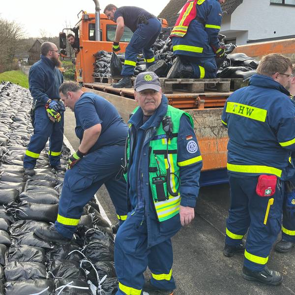 Einsatzkräfte von THW, Freiwilliger Feuerwehr, MHD sowie MitarbeiterInnen der Stadt am aufgeweichten Deich