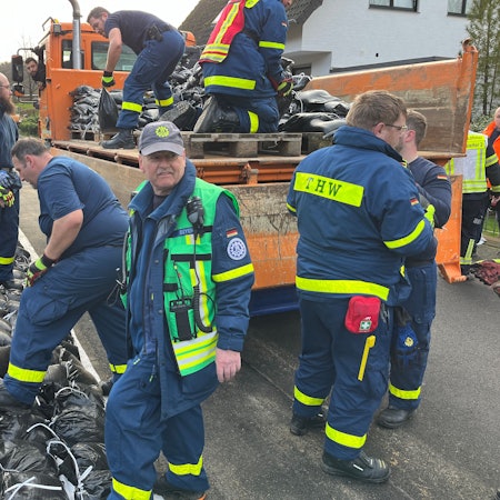 Einsatzkräfte von THW, Freiwilliger Feuerwehr, MHD sowie MitarbeiterInnen der Stadt am aufgeweichten Deich