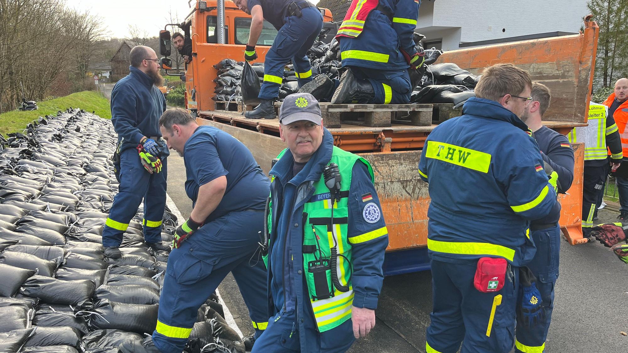 Einsatzkräfte von THW, Freiwilliger Feuerwehr, MHD sowie MitarbeiterInnen der Stadt am aufgeweichten Deich