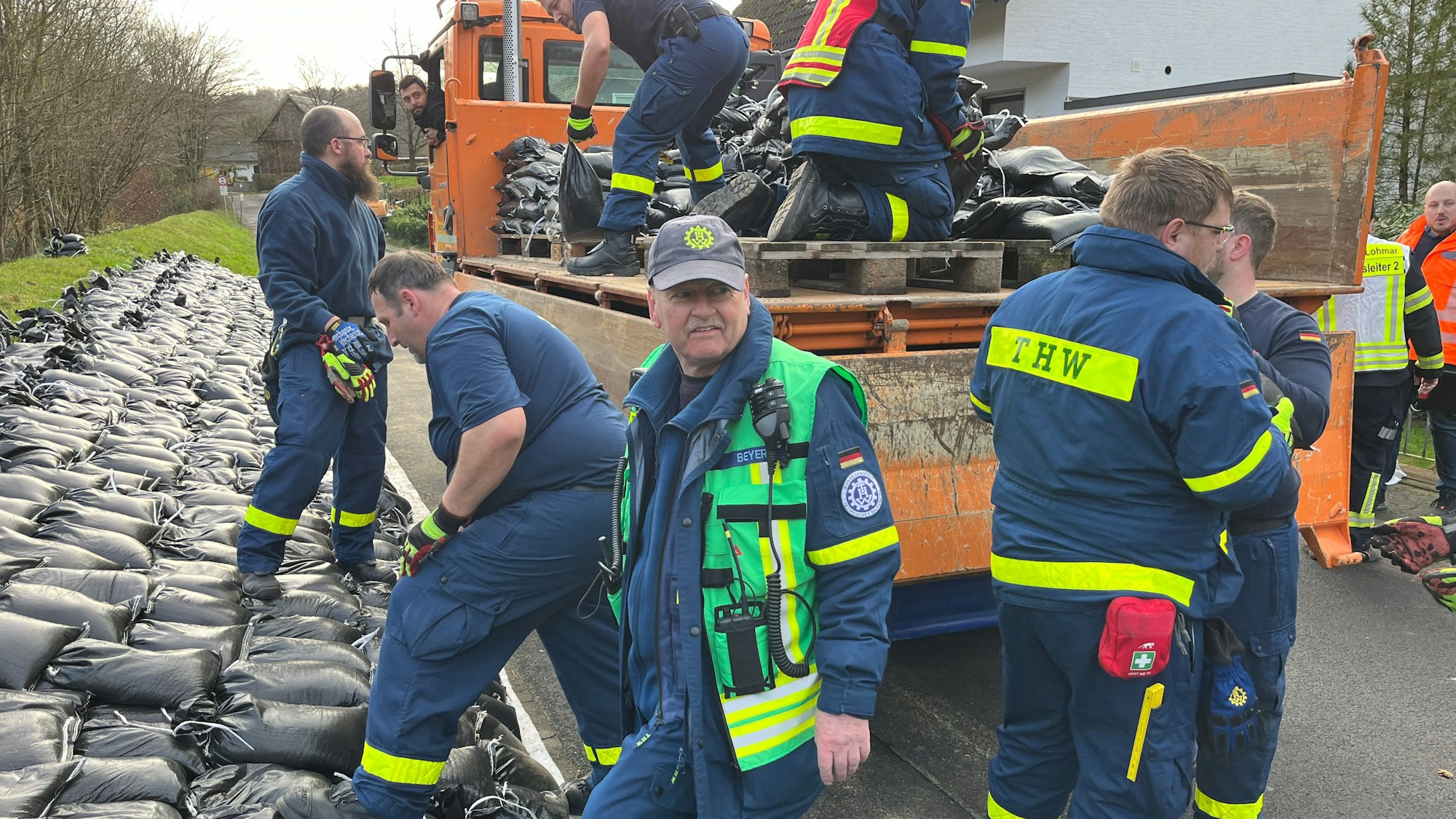 Einsatzkräfte von THW, Freiwilliger Feuerwehr, MHD sowie MitarbeiterInnen der Stadt am aufgeweichten Deich