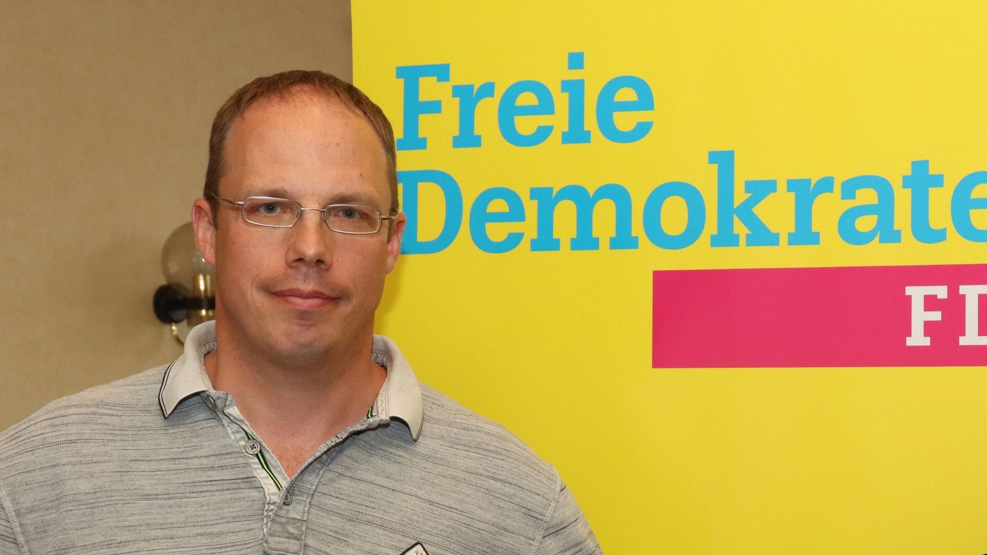 Ein Mann vor einem Banner der FDP.
