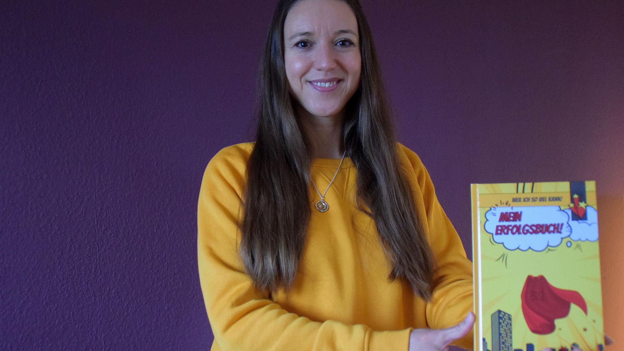 Die Autorin Kathleen Bienert hält ihr Buch in die Kamera.