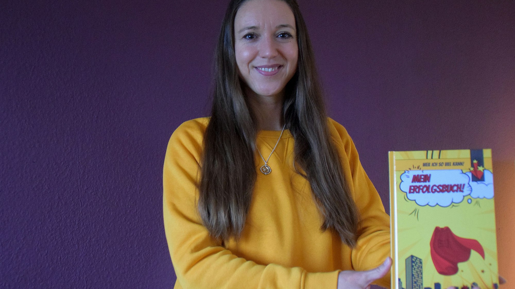 Die Autorin Kathleen Bienert hält ihr Buch in die Kamera.