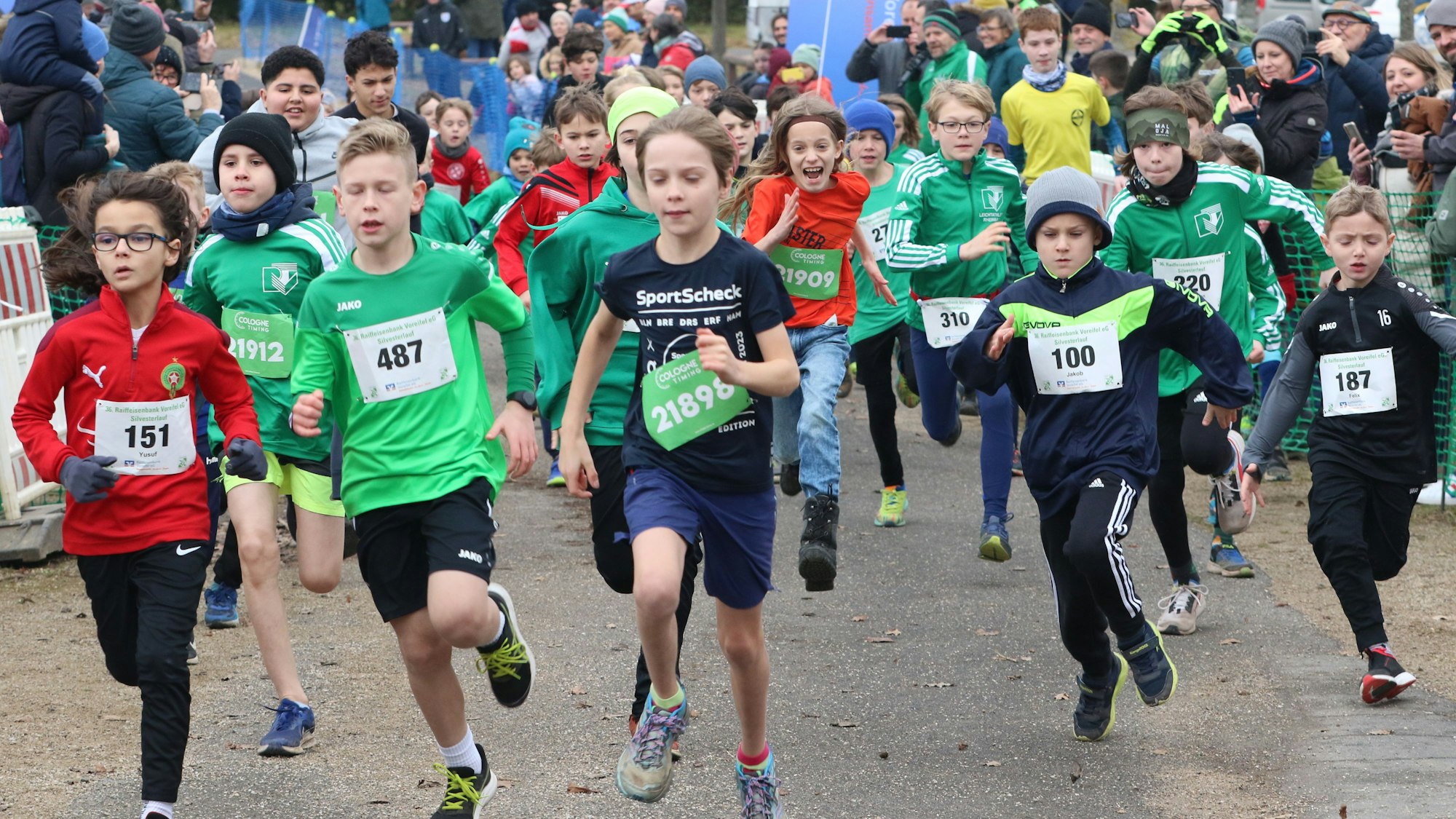 Der Läufernachwuchs sprintet nach dem Startschuss los. Das Bild zeigt viele laufende Kinder.