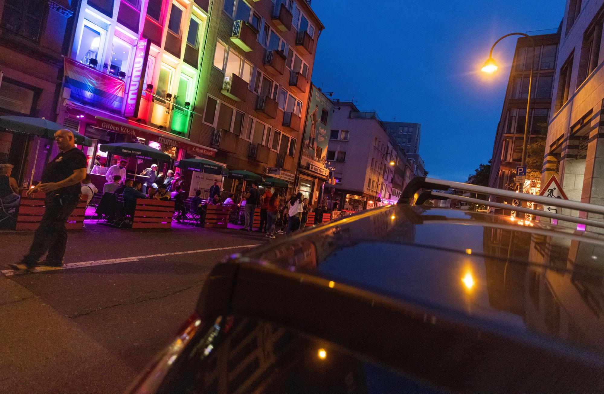 Eine Hauswand in der Schaafenstraße ist in Farben eines Regenbogens angestrahlt.