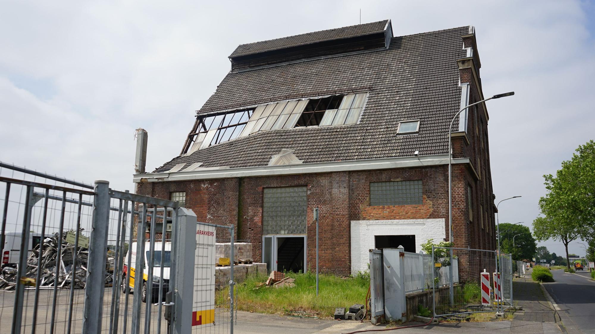 Ein Gebäude der alten Glasfabrik. Fenster sind kaputt, Ziegel bröckeln.