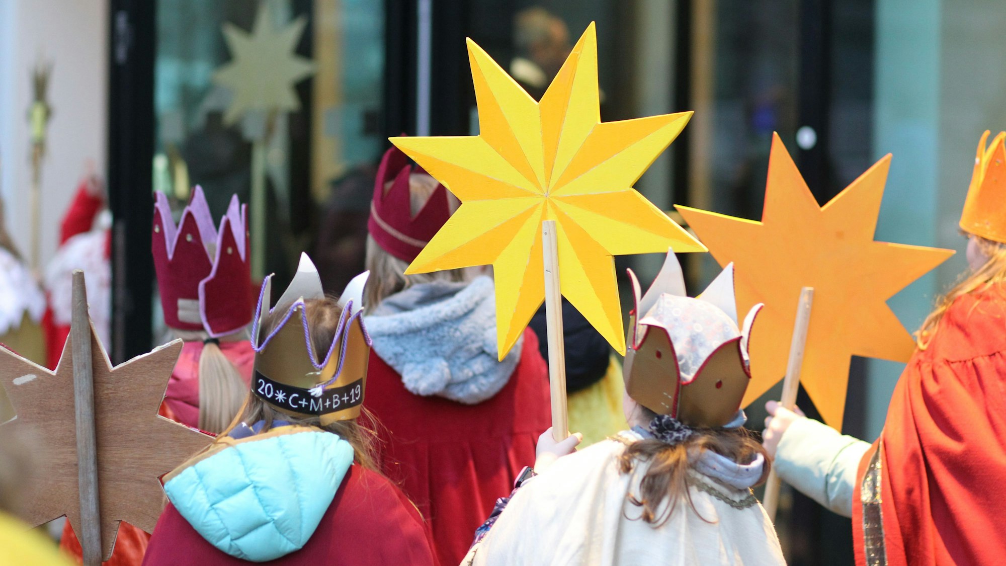 Kinder in den Kostümen der Sternsinger mit Sternen und selbst gebastelten Kronen.
