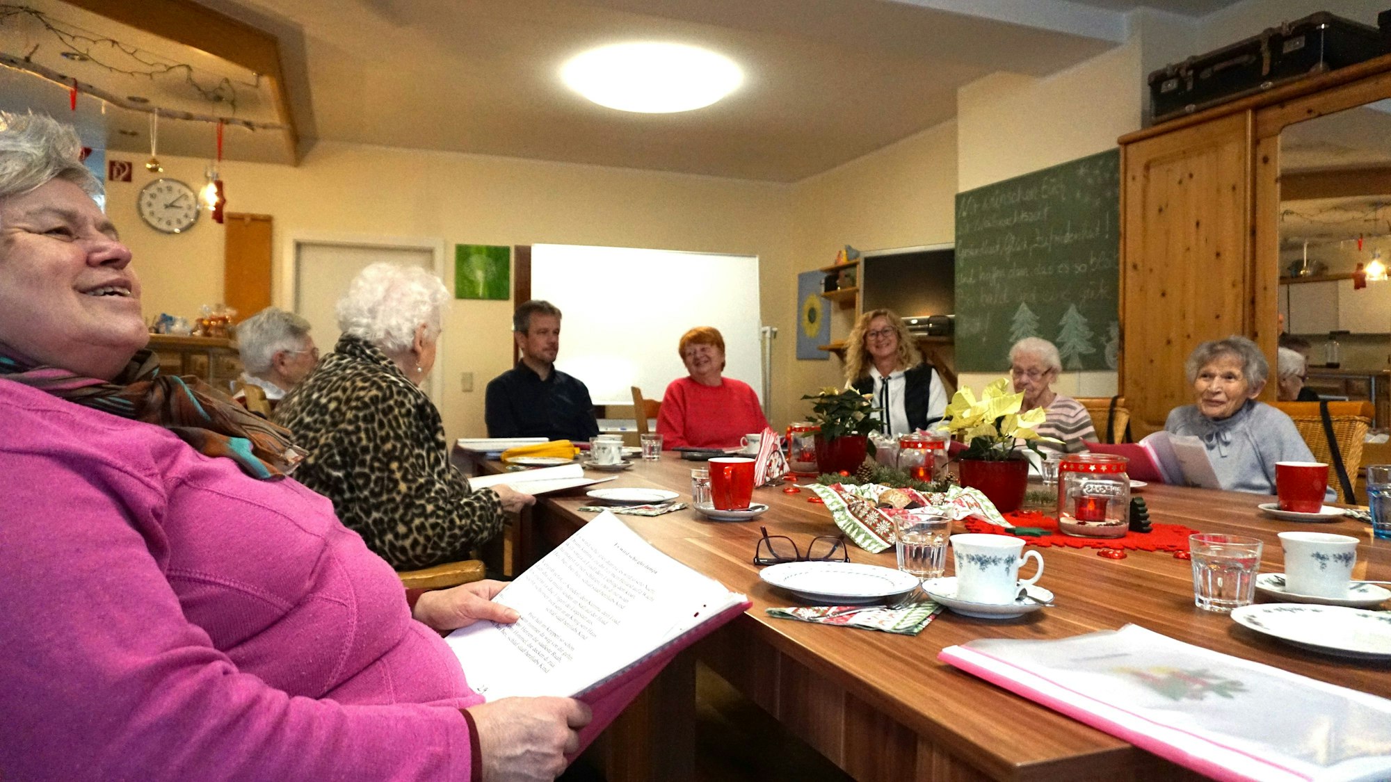 An einem weihnachtlich geschmücktem Tisch sitzen die Besucherinnen des Demenzcafés in Euskirchen.
