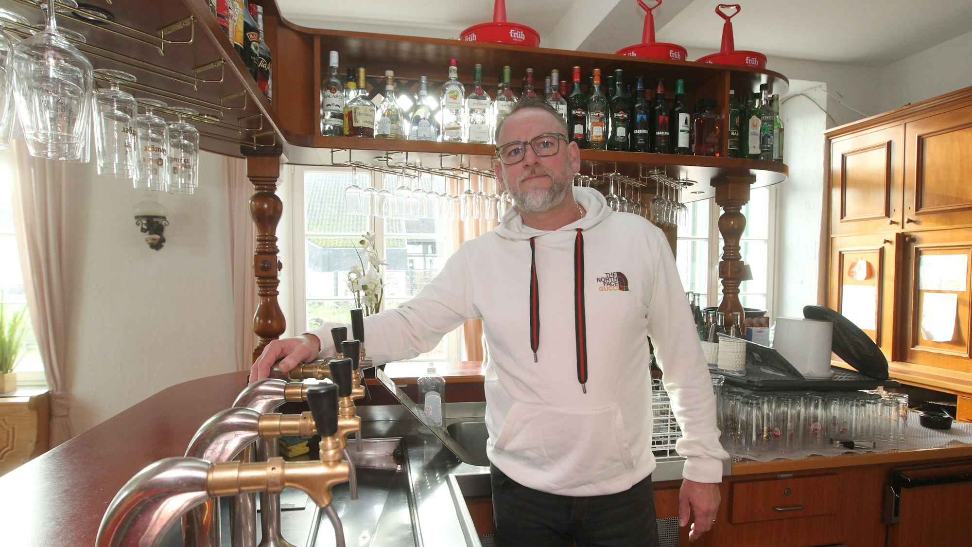 Ein Mann im Kapuzenpullover steht an einer Theke.