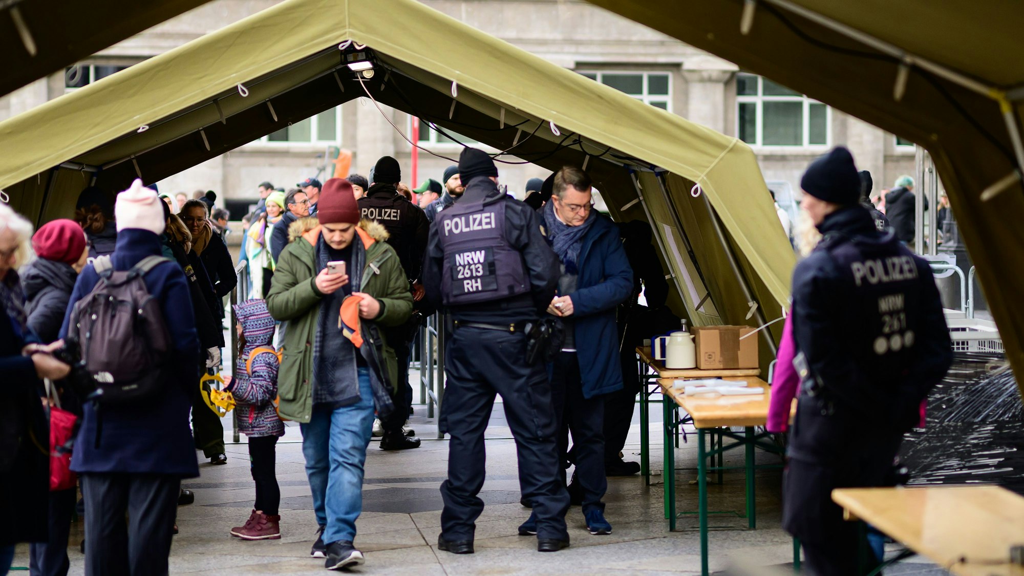Polizisten stehen in Zelten, in denen die Sicherheitskontrollen stattfinden.
