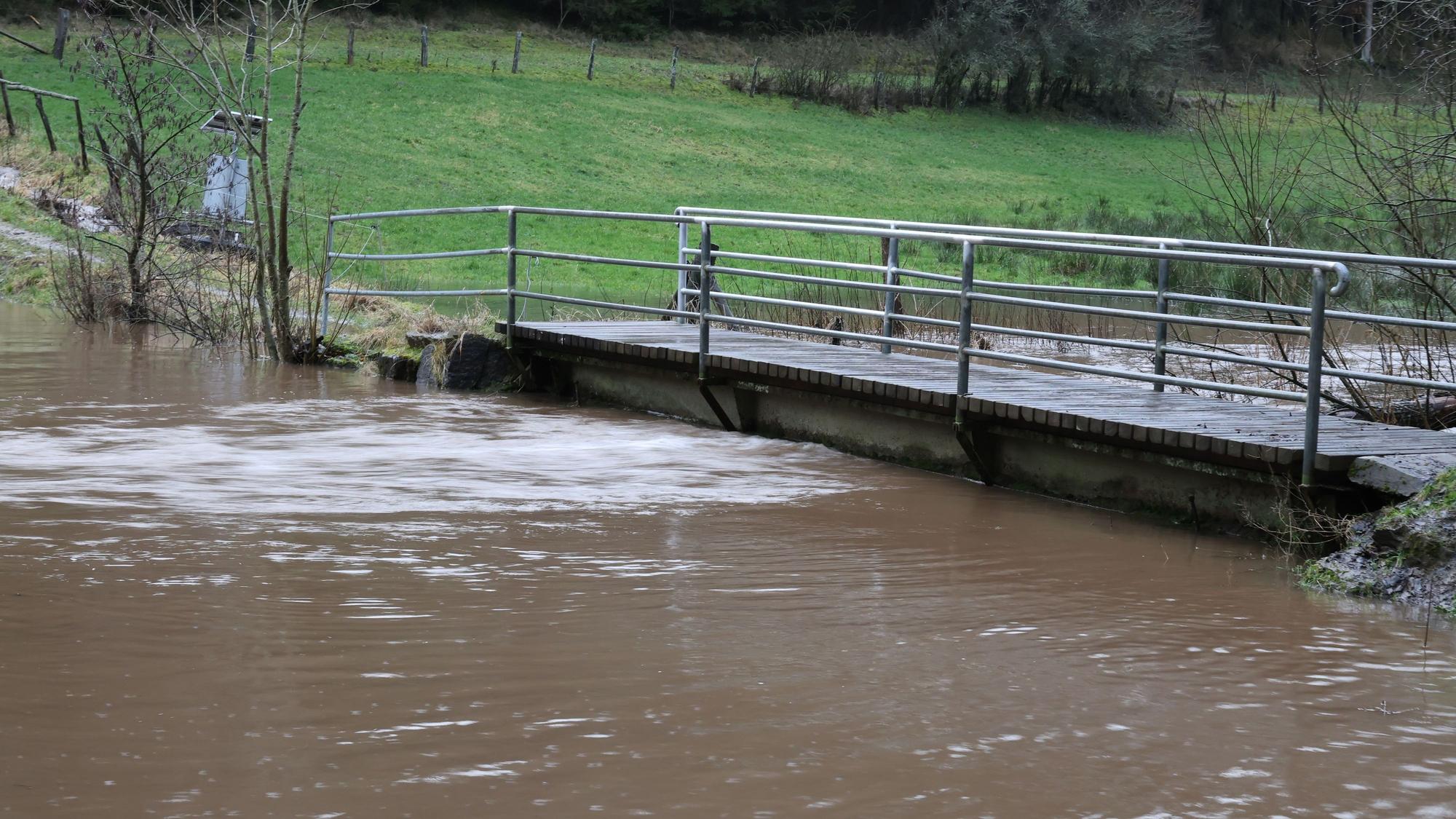 Der Wolferter Bach ist über die Ufer getreten, das Wasser steht bis n führt Hochwasser.